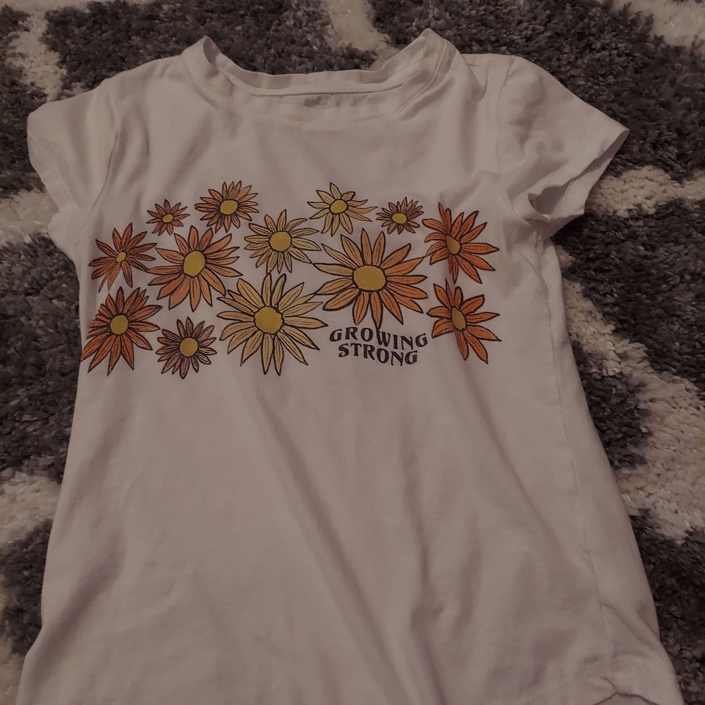 White shirt with flowers and words saying growing strong